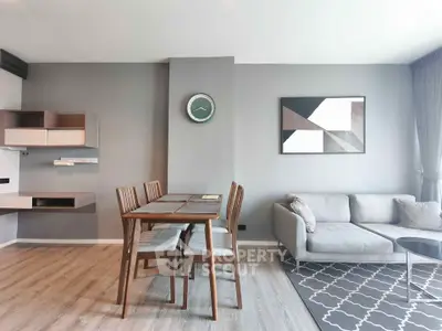Modern living room with stylish decor and dining area, featuring a cozy sofa and elegant wall art.