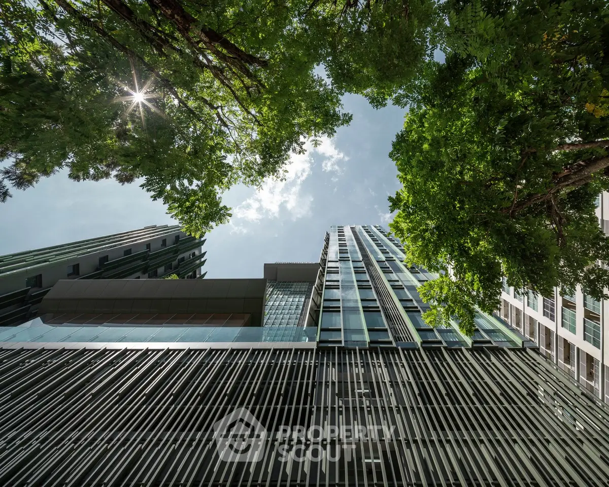 Stunning modern building exterior with lush greenery and clear sky view.