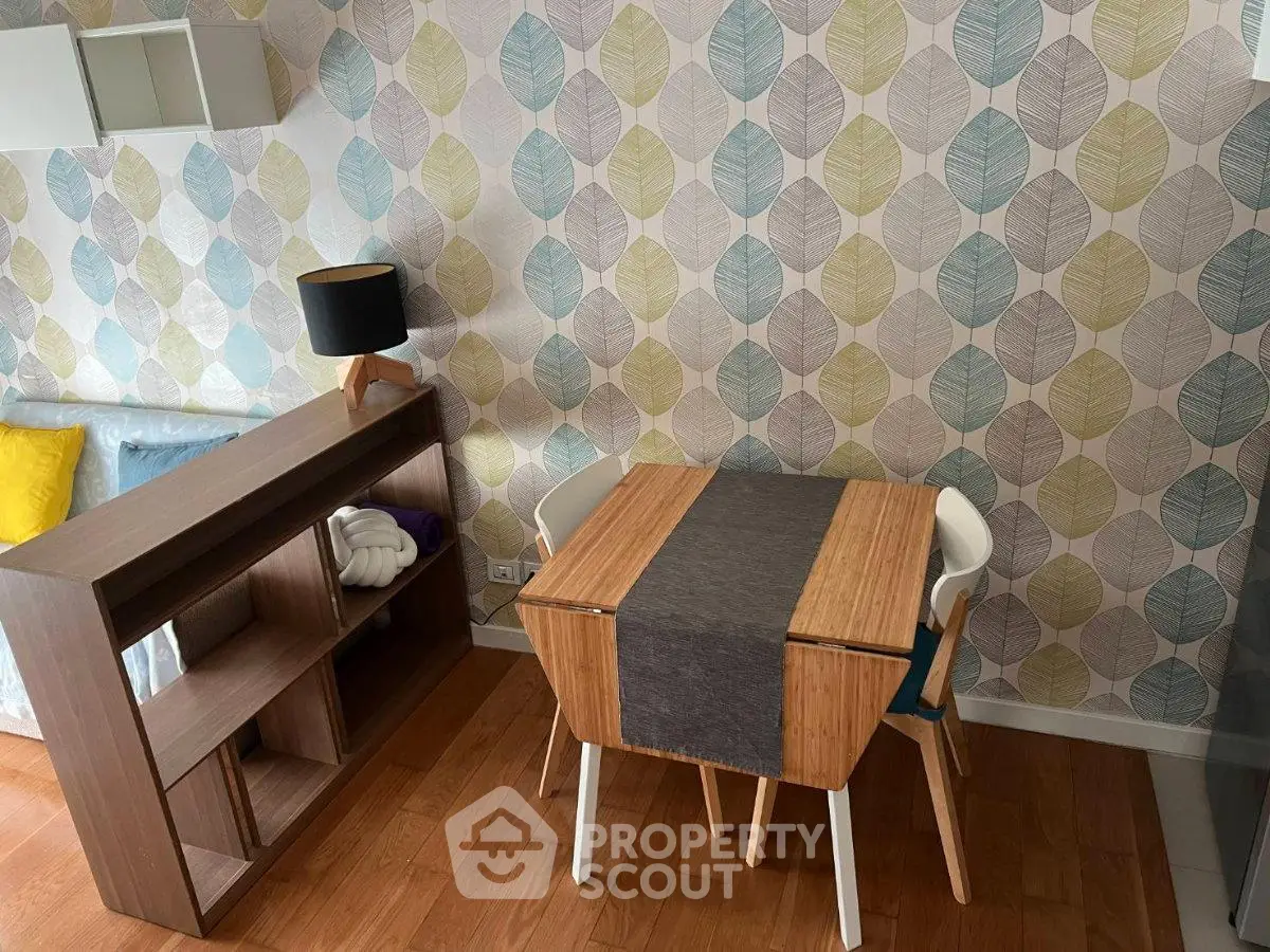 Charming living room with stylish wallpaper and cozy dining area, perfect for modern living.