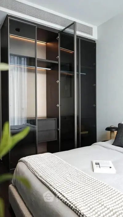 Modern bedroom with sleek glass wardrobe and cozy bedding