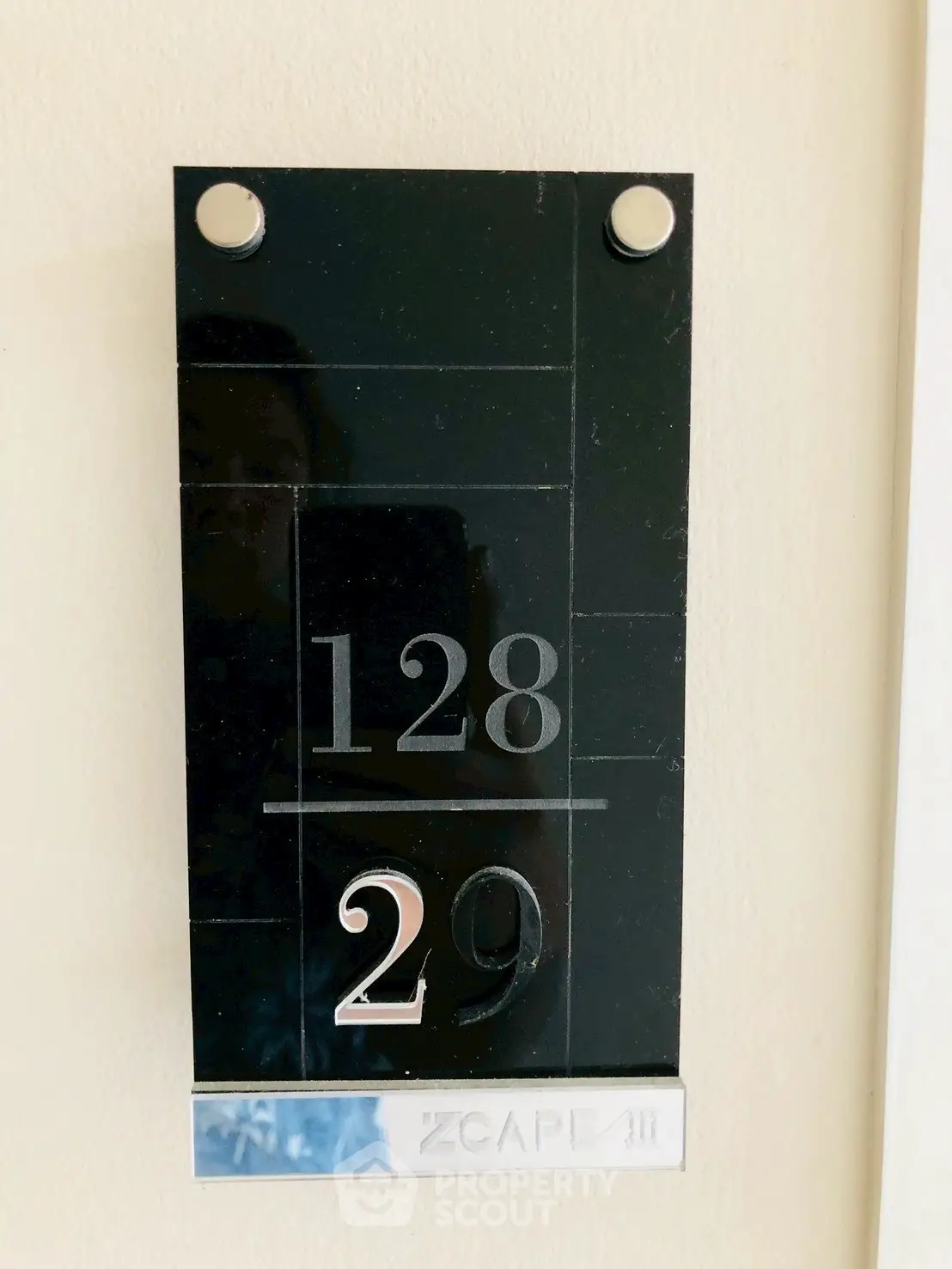 Modern apartment number plaque with sleek design and metallic accents.