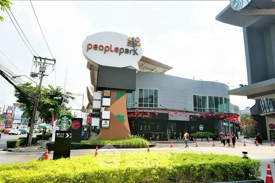 Modern shopping center exterior with vibrant signage and lush landscaping.