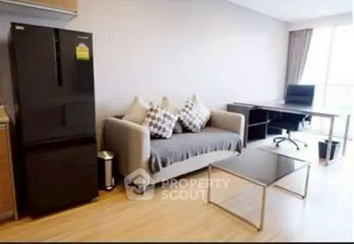 Modern living room with sleek furniture and workspace setup.