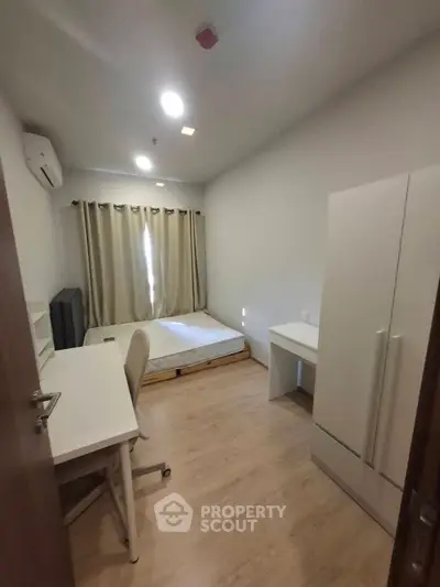 Cozy bedroom with modern furniture, featuring a bed, desk, and wardrobe, ideal for comfortable living.