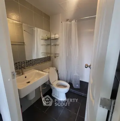 Modern bathroom with sleek fixtures and tiled walls, featuring a shower and toilet.