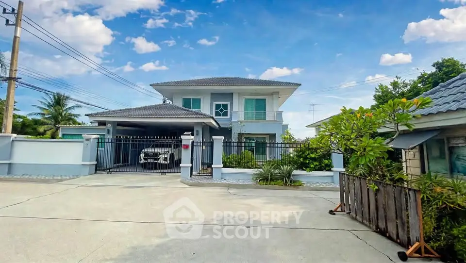 Stunning two-story house with spacious driveway and lush greenery under a clear blue sky.