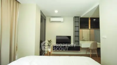 Modern bedroom with TV, air conditioning, and stylish decor in a cozy apartment.