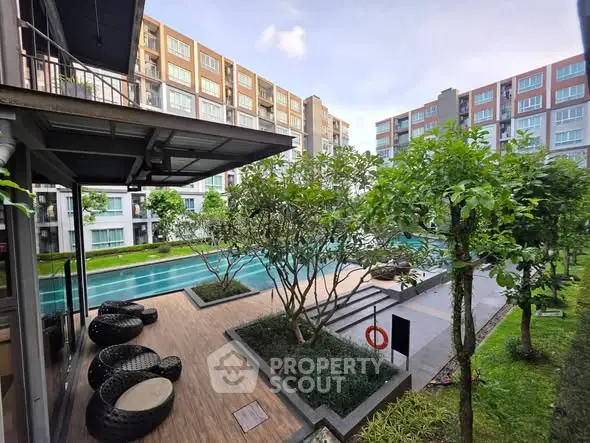 Modern apartment complex with lush garden and inviting pool area, perfect for relaxation and leisure.