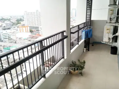 Spacious balcony with city view in high-rise apartment, perfect for relaxation and enjoying urban scenery.