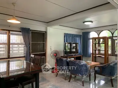 Spacious living room with dining area and large windows in a cozy home.