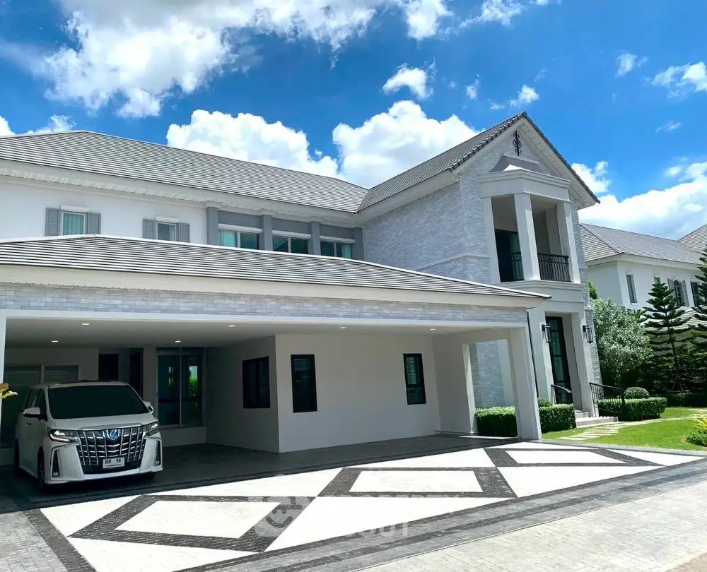 Luxurious modern mansion with spacious driveway and elegant architectural design under a clear blue sky.