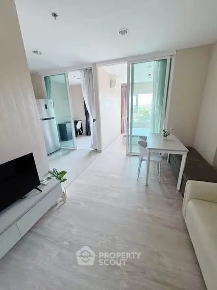 Modern open-plan living room with sleek furniture and balcony view in a stylish apartment.