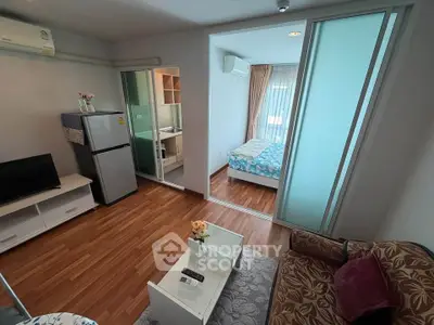 Modern apartment with open living room and cozy bedroom, featuring stylish decor and wooden flooring.