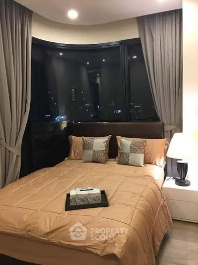 Luxurious bedroom with city view, elegant bedding, and ambient lighting.