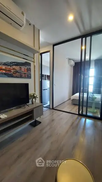 Modern apartment interior with glass partition, sleek flooring, and stylish decor.
