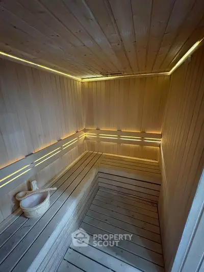 Luxurious wooden sauna with ambient lighting and traditional sauna accessories.