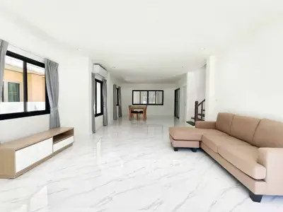 Spacious modern living room with elegant marble flooring and stylish furniture.