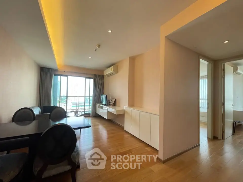 Spacious modern living room with wooden flooring and balcony view