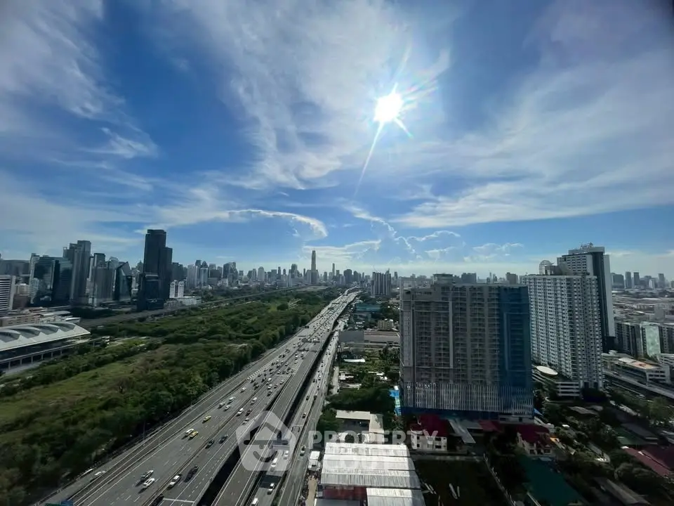Stunning cityscape view from high-rise building with clear blue sky and highway below.