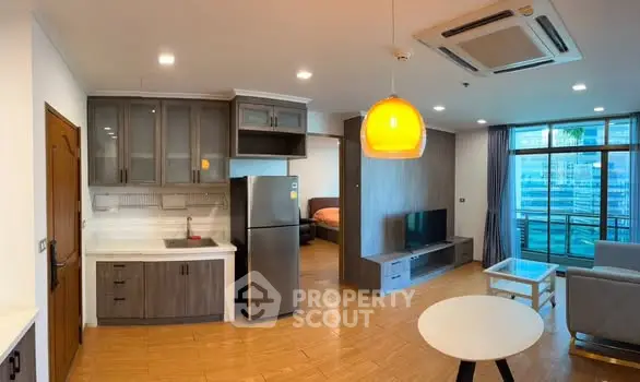 Modern open-plan living room with kitchen and balcony view