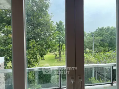 Scenic garden view from a modern balcony with lush greenery.