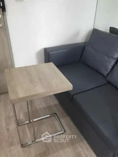 Modern living room with sleek gray sofa and stylish wooden side table.