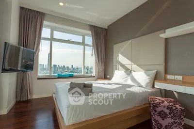 Luxurious bedroom with city view, modern decor, and natural light.
