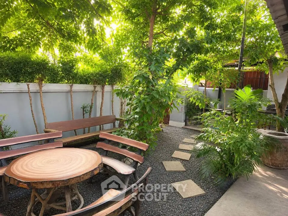 Charming garden with rustic wooden seating and lush greenery, perfect for outdoor relaxation and entertaining.