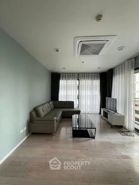 Spacious modern living room with sleek furniture and large windows for natural light.