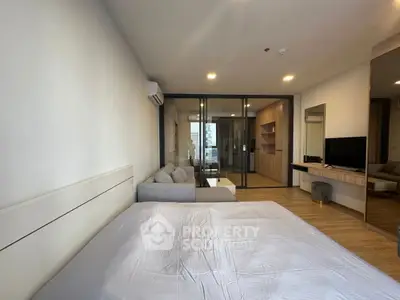 Modern bedroom with glass partition and cozy living area in stylish apartment