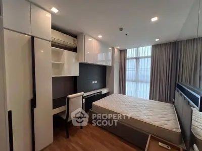 Modern bedroom with built-in storage and study area, featuring large windows and sleek design.