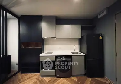 Modern kitchen with sleek appliances and stylish cabinetry in a contemporary apartment.