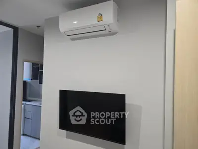 Modern interior with wall-mounted TV and air conditioning unit in a sleek apartment.