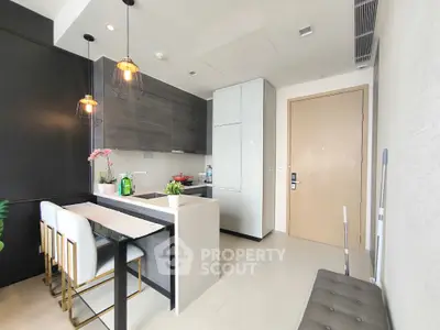 Modern kitchen with sleek design, open layout, and stylish lighting fixtures.