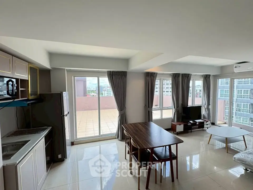 Spacious modern living room with large windows and balcony access in urban apartment.