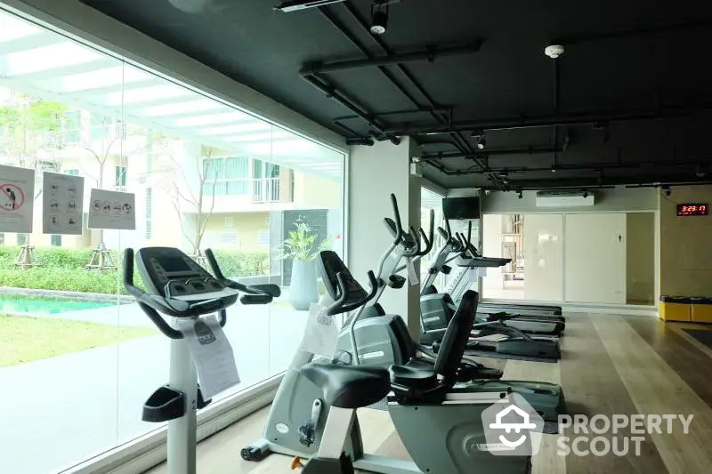 Modern gym facility with state-of-the-art exercise bikes overlooking a serene outdoor view, perfect for a healthy lifestyle.