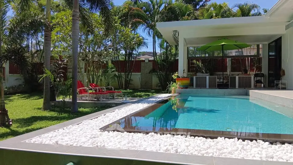 Luxurious modern home with stunning pool and lush garden, perfect for relaxation and entertainment.