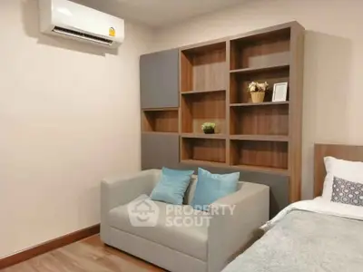 Cozy bedroom with modern shelving and air conditioning, perfect for relaxation and comfort.