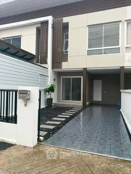 Modern townhouse exterior with sleek design and spacious driveway