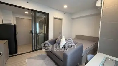 Modern studio apartment with sleek design and cozy furnishings, featuring a compact living area and stylish decor.