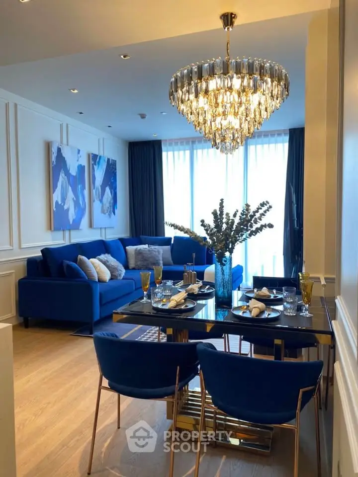 Luxurious living room with elegant chandelier and modern blue decor, perfect for stylish urban living.