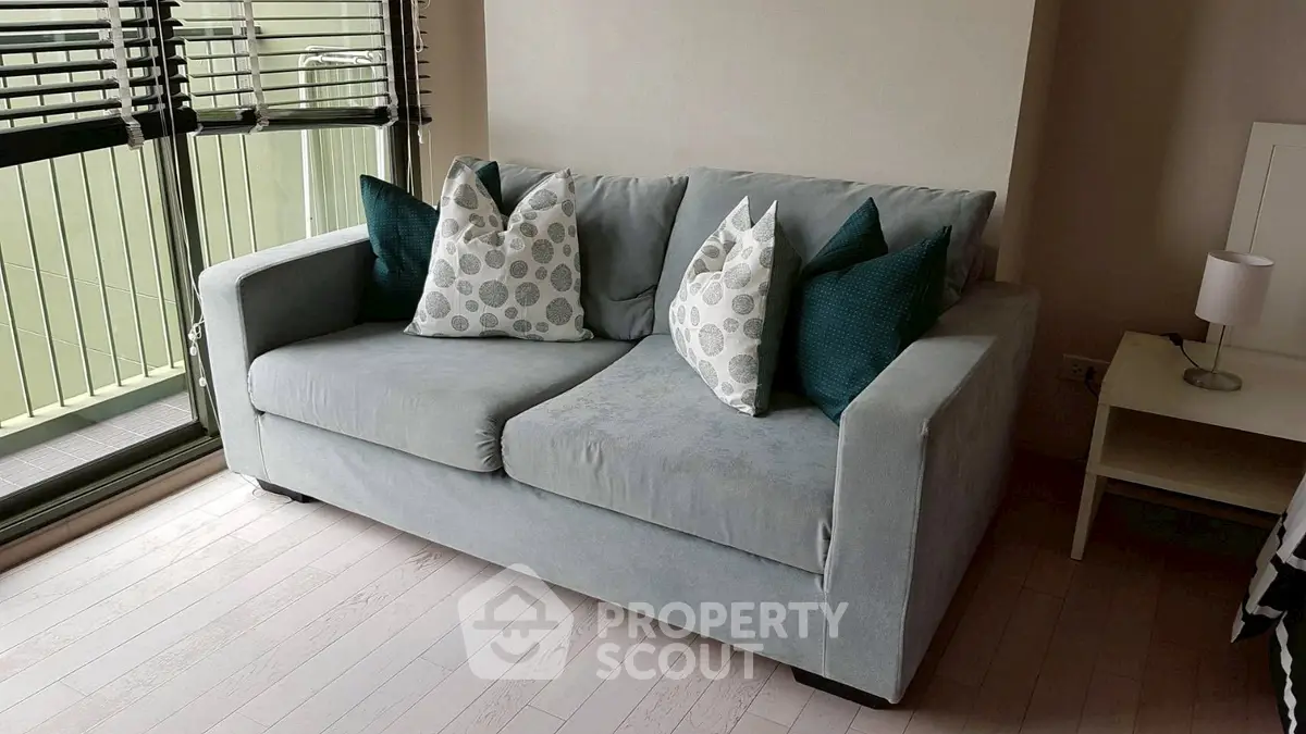 Cozy living room with stylish gray sofa and decorative pillows, perfect for relaxation.