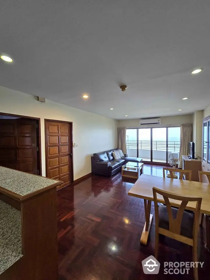 Spacious living room with wooden flooring and balcony view