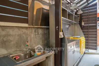 Modern outdoor kitchen with stainless steel appliances and rustic concrete sink