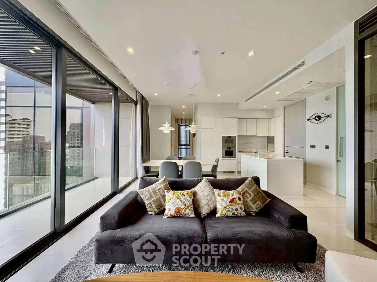 Luxurious modern living room with panoramic city views and sleek open kitchen layout.