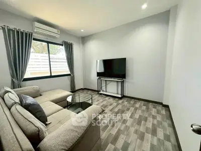Modern living room with cozy sofa and large TV, perfect for relaxation.