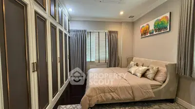 Elegant bedroom with plush bed and spacious wardrobe in modern apartment