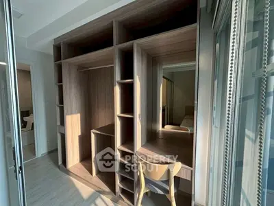 Spacious walk-in closet with wooden shelves and natural light, perfect for organized living.