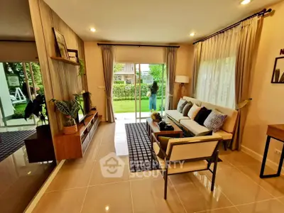 Spacious living room with modern decor and garden view, perfect for relaxation and entertaining guests.