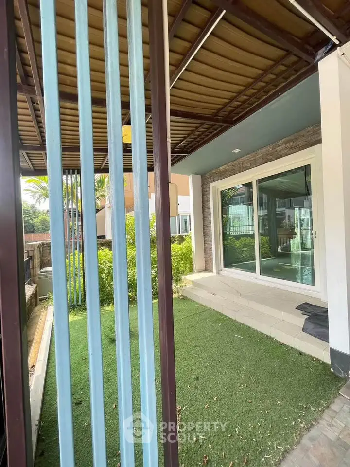 Charming garden patio with sliding glass doors and lush greenery, perfect for relaxation and outdoor enjoyment.
